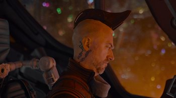 Movie still from “The Guardians of the Galaxy Holiday Special” (2022), directed by James Gunn – A bald man with a hat on his head; Close Up shot, Over the shoulder angle