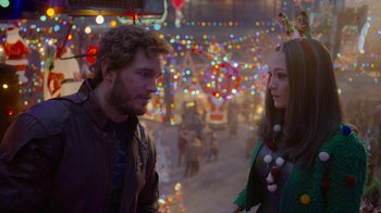 Movie still from “The Guardians of the Galaxy Holiday Special” (2022), directed by James Gunn – A man and a woman standing next to each other in front of christmas lights; Close Up shot, Over the shoulder angle