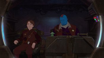 Movie still from “The Guardians of the Galaxy Holiday Special” (2022), directed by James Gunn – A man sitting next to another man in a room; Medium shot, High angle