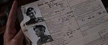 Movie still from “The Guns of Navarone” (1961), directed by J. Lee Thompson – A page of an old book with a picture of an older man; Extreme Close Up shot, Overhead angle