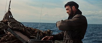 Movie still from “The Guns of Navarone” (1961), directed by J. Lee Thompson – A man standing next to a body of water; Medium shot, Low angle