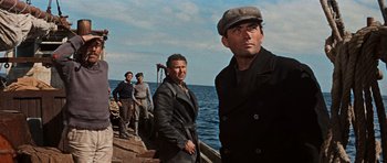 Movie still from “The Guns of Navarone” (1961), directed by J. Lee Thompson – A group of men standing next to each other on a boat; Medium shot, Low angle