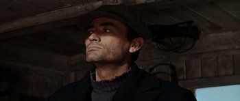Movie still from “The Guns of Navarone” (1961), directed by J. Lee Thompson – A person wearing a hat and a jacket; Close Up shot, Low angle