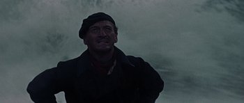 Movie still from “The Guns of Navarone” (1961), directed by J. Lee Thompson – A man in a black jacket and a black hat looking up; Close Up shot, Low angle