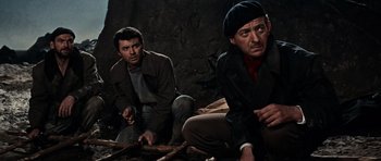 Movie still from “The Guns of Navarone” (1961), directed by J. Lee Thompson – Two men sitting next to each other on the ground; Medium shot, High angle