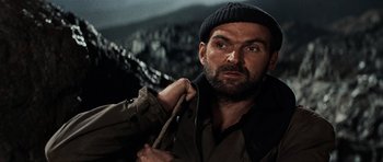 Movie still from “The Guns of Navarone” (1961), directed by J. Lee Thompson – A person wearing a jacket and a hat; Close Up shot, Low angle