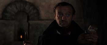 Movie still from “The Guns of Navarone” (1961), directed by J. Lee Thompson – A man in a black coat looking at the camera; Close Up shot, Low angle