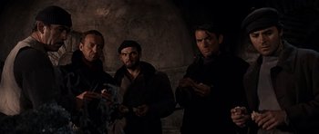 Movie still from “The Guns of Navarone” (1961), directed by J. Lee Thompson – A group of men standing next to each other in the dark; Medium shot, Low angle