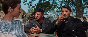 Movie still from “The Guns of Navarone” (1961), directed by J. Lee Thompson – A group of men sitting at a table with a bottle; Medium shot, Low angle