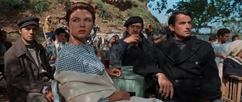 Movie still from “The Guns of Navarone” (1961), directed by J. Lee Thompson – A woman sitting next to two men drinking wine; Medium shot, Low angle