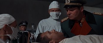 Movie still from “The Guns of Navarone” (1961), directed by J. Lee Thompson – A man in a hospital bed with a doctor and a nurse; Medium shot, Low angle