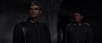 Movie still from “The Guns of Navarone” (1961), directed by J. Lee Thompson – Two men in uniforms stand in a dark room; Medium shot, Low angle