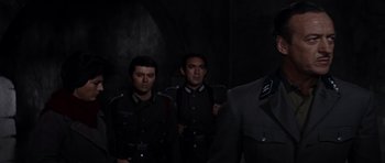 Movie still from “The Guns of Navarone” (1961), directed by J. Lee Thompson – A group of men standing next to each other in uniforms; Medium shot, Low angle