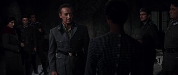 Movie still from “The Guns of Navarone” (1961), directed by J. Lee Thompson – A man and a woman are standing next to each other; Medium shot, Over the shoulder angle