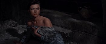Movie still from “The Guns of Navarone” (1961), directed by J. Lee Thompson – A beautiful woman holding onto a bag while sitting on the ground; Close Up shot, High angle