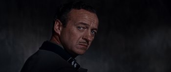 Movie still from “The Guns of Navarone” (1961), directed by J. Lee Thompson – A person wearing a suit and tie; Close Up shot, Low angle