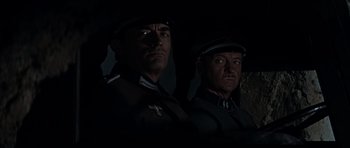 Movie still from “The Guns of Navarone” (1961), directed by J. Lee Thompson – A couple of men standing next to each other in uniform; Close Up shot, Low angle