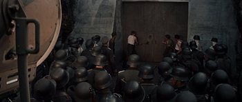 Movie still from “The Guns of Navarone” (1961), directed by J. Lee Thompson – A group of men standing next to each other in front of a wall; Wide shot, High angle