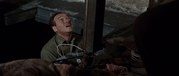 Movie still from “The Guns of Navarone” (1961), directed by J. Lee Thompson – A man is laying on the ground with his mouth open; Medium shot, Overhead angle