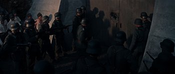 Movie still from “The Guns of Navarone” (1961), directed by J. Lee Thompson – A group of men standing next to each other in a room; Wide shot, High angle