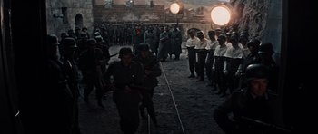 Movie still from “The Guns of Navarone” (1961), directed by J. Lee Thompson – A group of men in uniforms are standing in front of a crowd; Wide shot, High angle