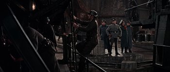 Movie still from “The Guns of Navarone” (1961), directed by J. Lee Thompson – A group of men standing next to a railing; Wide shot, High angle