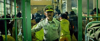 Movie still from “The Hangover Part III” (2013), directed by Todd Phillips – An older man in uniform standing in front of a group of people; Medium shot, Over the shoulder angle