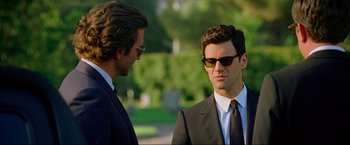 Movie still from “The Hangover Part III” (2013), directed by Todd Phillips – A man in a suit and sunglasses talking to another man; Close Up shot, Over the shoulder angle