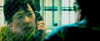 Movie still from “The Hangover Part III” (2013), directed by Todd Phillips – A man talking on a cell phone in front of a window; Close Up shot, Over the shoulder angle