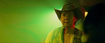 Movie still from “The Hangover Part III” (2013), directed by Todd Phillips – A man wearing a cowboy hat is holding a microphone; Close Up shot, Low angle