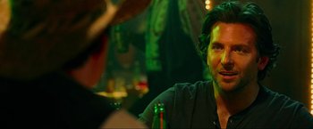 Movie still from “The Hangover Part III” (2013), directed by Todd Phillips – A man sitting at a table with a bottle of beer in front of him; Close Up shot, Over the shoulder angle