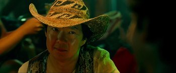 Movie still from “The Hangover Part III” (2013), directed by Todd Phillips – A person wearing a straw hat and a yellow scarf; Close Up shot, Over the shoulder angle