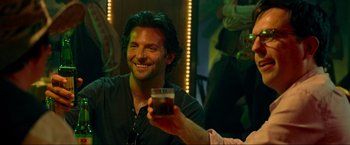 Movie still from “The Hangover Part III” (2013), directed by Todd Phillips – A man smiling while holding up a glass of beer; Close Up shot, Over the shoulder angle