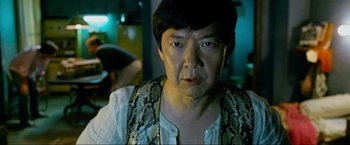 Movie still from “The Hangover Part III” (2013), directed by Todd Phillips – A person wearing a snake skin vest; Close Up shot, Over the shoulder angle