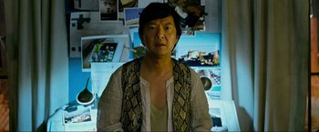 Movie still from “The Hangover Part III” (2013), directed by Todd Phillips – A man in a white shirt and a snakeskin print vest; Medium shot, Over the shoulder angle