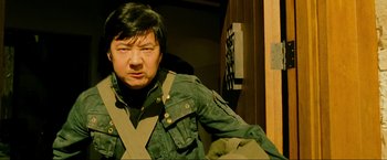 Movie still from “The Hangover Part III” (2013), directed by Todd Phillips – A man wearing a green jacket and a black shirt; Medium shot, Low angle