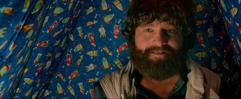 Movie still from “The Hangover Part III” (2013), directed by Todd Phillips – A man with a long beard and a blue umbrella; Close Up shot, Over the shoulder angle