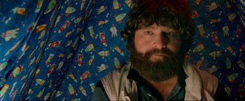 Movie still from “The Hangover Part III” (2013), directed by Todd Phillips – A man with a beard holding an open umbrella; Close Up shot, Over the shoulder angle