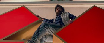 Movie still from “The Hangover Part III” (2013), directed by Todd Phillips – A man sitting on the side of a building; Wide shot, Overhead angle