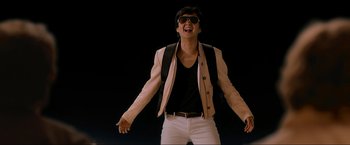 Movie still from “The Hangover Part III” (2013), directed by Todd Phillips – A young man wearing sunglasses and a white jacket; Medium shot, Low angle