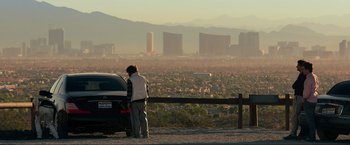 Movie still from “The Hangover Part III” (2013), directed by Todd Phillips – A person standing next to a car on a road; Wide shot, Over the shoulder angle