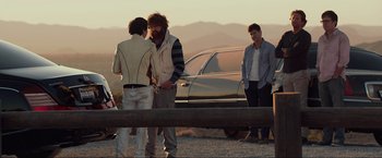 Movie still from “The Hangover Part III” (2013), directed by Todd Phillips – A group of people standing next to each other near a car; Wide shot, Over the shoulder angle