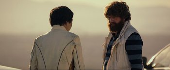 Movie still from “The Hangover Part III” (2013), directed by Todd Phillips – Two people standing next to each other on a field; Medium shot, Over the shoulder angle