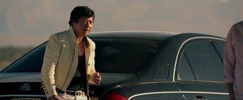 Movie still from “The Hangover Part III” (2013), directed by Todd Phillips – A man standing in front of a black car; Medium shot, Low angle