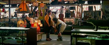Movie still from “The Hangover Part III” (2013), directed by Todd Phillips – A man and a woman looking at a lamp in a store; Wide shot, Over the shoulder angle