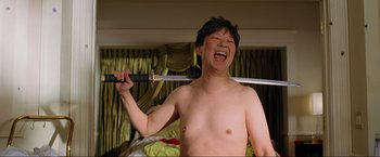 Movie still from “The Hangover Part III” (2013), directed by Todd Phillips – A shirtless man holding a sword in a room; Medium shot, Low angle