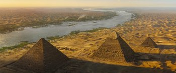 Movie still from “Death on the Nile” (2022), directed by Kenneth Branagh – An aerial view of the pyramids of gizeh , egypt; Extreme Wide shot, Overhead angle