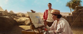 Movie still from “Death on the Nile” (2022), directed by Kenneth Branagh – A man and a woman are painting in the desert; Medium shot, Over the shoulder angle