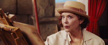 Movie still from “Death on the Nile” (2022), directed by Kenneth Branagh – An older woman wearing a hat looking into a mirror; Close Up shot, Over the shoulder angle