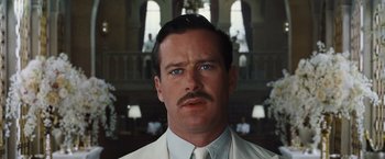 Movie still from “Death on the Nile” (2022), directed by Kenneth Branagh – A person wearing a suit and tie; Close Up shot, Low angle